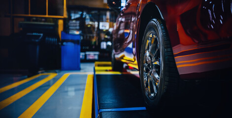 Closeup of Car wheel in garage of auto repair service shop. - obrazy, fototapety, plakaty