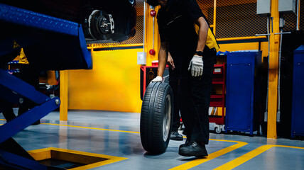 New tires Car mechanic brings new tires in stock  to the tire shop to change the wheel of the car.