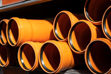 Stack of PVC U canalization pipes on a hardware store. Brown plastic  pipes. plumbing tube. Construction Materials