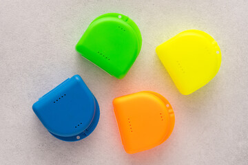 Multi-colored containers for dental plates. Box for orthodontic mouthguard