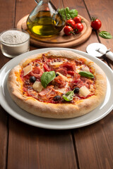 Deliziosa pizza italiana condita con mozzarella, sugo, olive nere, prosciutto cotto e scaglie di grana 