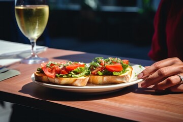  hand with appetizer bruschetta with tomatoes with glass on a white wine.cafe. restaurant
