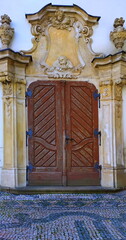 Double heavy wooden and monumental church or castle doors with metal decoration and images of angels made of concrete