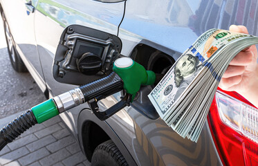 Fuel nozzle to release fuel into passenger car at the gas station - obrazy, fototapety, plakaty