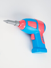 children's electric drill close-up.
children's colorful plastic construction set, which includes an electric drill, screws, bolts and screwdrivers.
