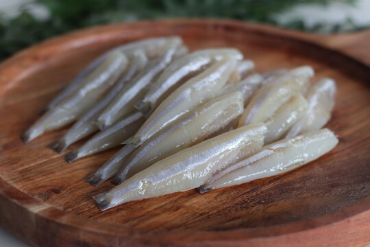 Freshly cut and cleaned anchovy fish presented on a rustic wooden tray