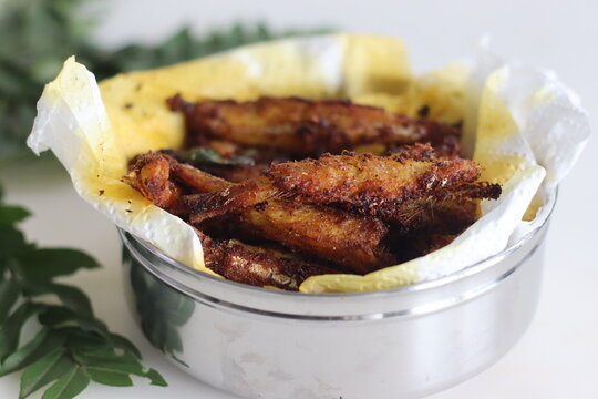 Delicious anchovy fish fry, crispy and golden brown, served on a plate with garnish