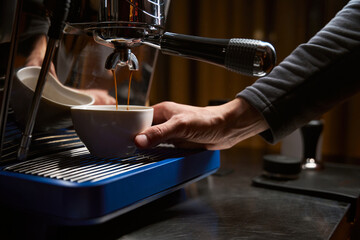 Hands of barista making coffee with espresso machine