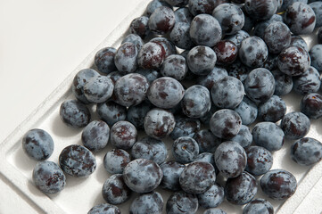 pile of ripe plums on a white background. Fruits from the home garden