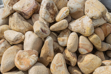 Beige Pebble stones including occasional cream inclusions closeup. Pebbles with a beautiful beige...