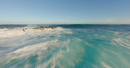 Aerial FPV drone footage of serene ocean waves and a majestic mountain landscape at sunrise, showcasing nature's beauty in dynamic, cinematic style