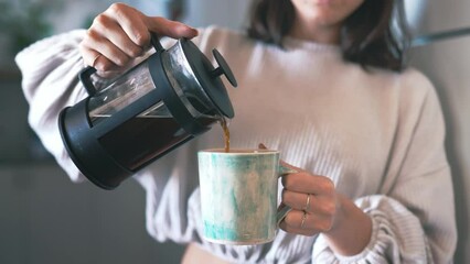 Closeup, woman and pouring herself coffee from a plunger, relax and caffeine in an apartment. Person, espresso and girl with a mug, morning and kitchen with breakfast drink, home and wake up routine