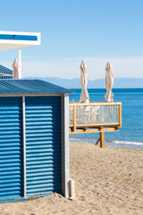 Chiringuito o restaurante de playa con sus mesas ,sillas y sombrilla mirando al mar mediterráneo con el horizonte al fondo y un día luminoso de sol