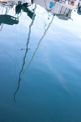Velas de un velero reflejadas en el agua del puerto deportivo de Fuengirola en el Costa del Sol de España