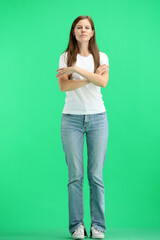 A woman, full-length, on a green background, crossed her arms