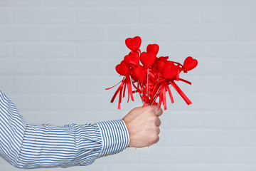 A Heart in human hands on white brick background