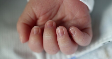 Newborn baby infant asleep, close-up of tiny little hand in macro detail