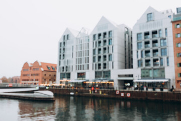 Obraz premium Blurred background of canal outside, modern city backdrop. Gdansk, Poland