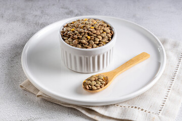 Green lentils in the bowl on the table.