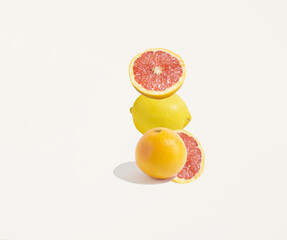 A pattern made of isolated fruits, an orange, a grapefruit and a lemon on a white background. Copy space, minimal fruit concept. Healthy, balanced diet.