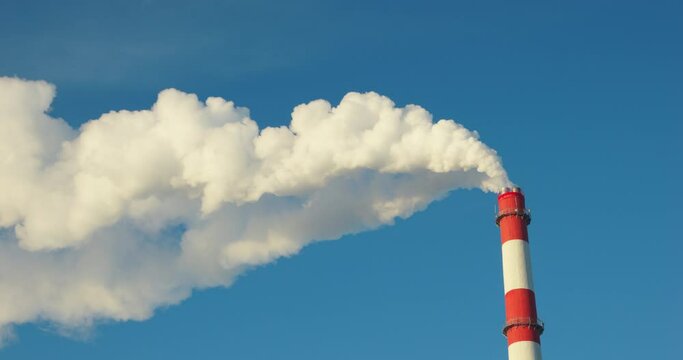 4K - Factory chimney emitting a long plume of smoke