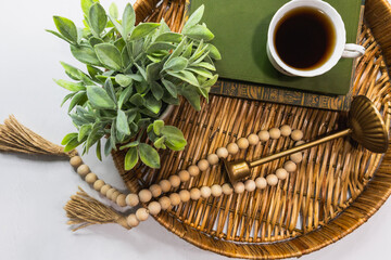 still life with tea on round wicker tray on white wooden table with copy space for mother's day or birthday