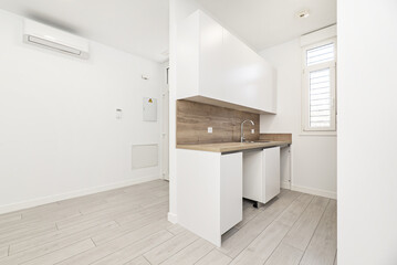 Small kitchen furnished in the absence of appliances, hallways in an open-plan room of a loft-type home