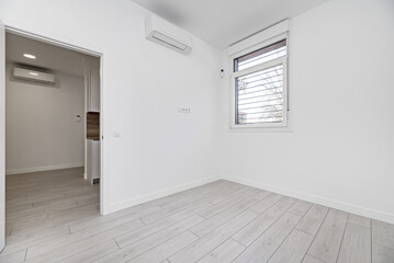 Empty room with light floors, access door to other rooms