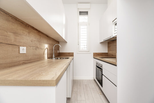 Newly installed small kitchen with plain white cabinets