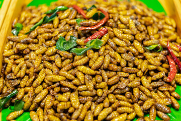 Thai street food, deep fried silk worms selling in the market or along the road side in different parts in Thailand