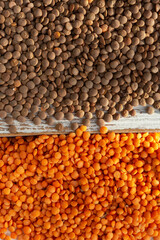 A close-up image showing two types of lentils, with brown lentils on the top and split red lentils