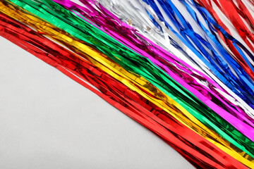 Multicolored, silver, reflective ribbons, diagonally positioned, filling two-thirds of the frame....
