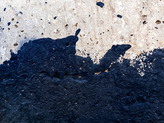 Dirty cement wall with black paint stains. Abstract black paint grunge background with copy space.