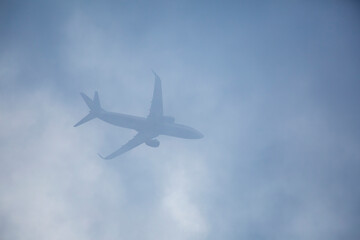 Passenger plane passing through the clouds