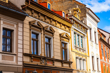 Row of Buildings on a City Street in Brasov, Romania, Transylvania. A picturesque view of a row of buildings on a lively city street, highlighting the charming Transylvanian architecture.