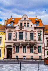 Fototapeta premium Building With Red Fire Hydrant in Front - Brasov, Romania, Transylvania Travel. A simple yet eye-catching image of a building with a vibrant red fire hydrant in the foreground.