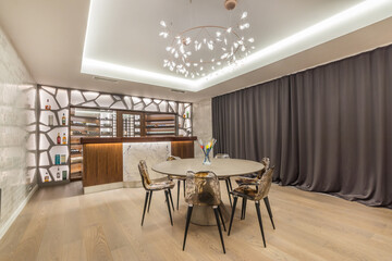 Stylish design of the living room with an original chandelier and a bar counter.