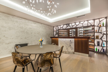 The interior of the living room with an exclusive design with chairs at the table and a bar counter.