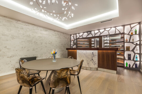 The interior of the living room with an exclusive design with chairs at the table and a bar counter.