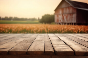 A weathered wooden tabletop overlooks a blurred view of a traditional red barn and golden field