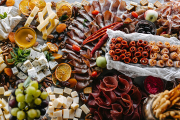 Gourmet charcuterie board filled with an assortment of meats, cheeses, and accompaniments, flatlay.