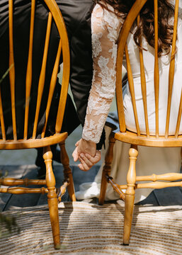 A couple holding hands under the table.