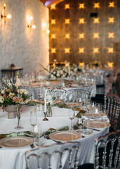 An elegantly set wedding reception table with plates, glasses and textile handkerchiefs.