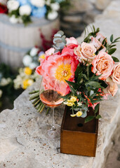 Obraz na płótnie Canvas A glass of rosé wine next to a vibrant floral bouquet.