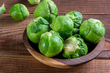 Fresh organic brussels sprouts raw in a plate on wooden background