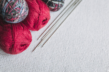 Skeins of wool yarn and needles for hand knitting on a grey background. Concept for handmade.