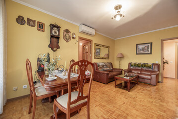 Living room of a house with classic-style wooden furniture with a dining table