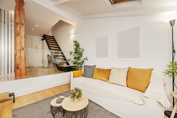 small loft-style house with wooden and metal stairs to access the second floor and living room