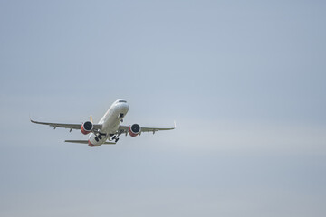 A cargo plane that uses all the power of the engines to take off by raising the landing gear in its compartments on a day with clear skies