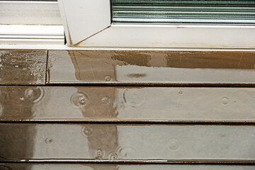 Wooden plank floor of a terrace filled with rainwater